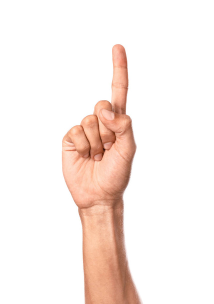 Mano masculina con dedo índice elevado sobre fondo blanco
 - Foto, imagen