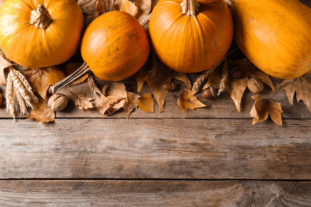 Ripe pumpkins on wooden background, flat lay with space for text. Holiday decoration - Valokuva, kuva