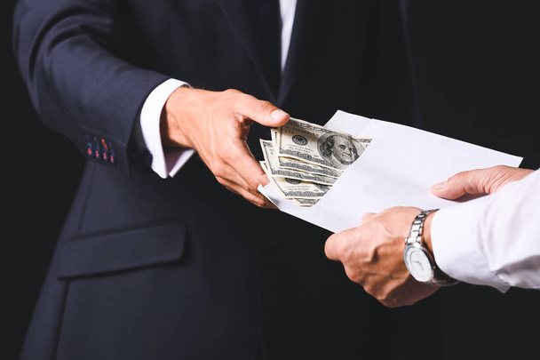 Businessman taking bribe against dark background, closeup - Photo, Image