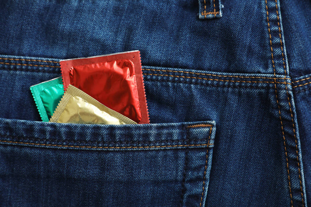 Closeup view of jeans with condoms in pocket. Safe sex concept - Foto, afbeelding