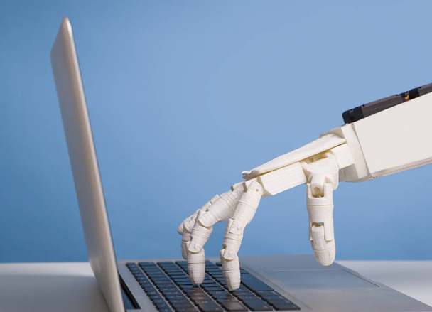 Robotic hand typing on laptop keyboard, free space - 写真・画像