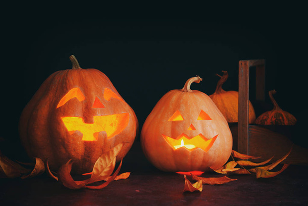 Halloween pumpkins with leaves on dark background - Фото, зображення