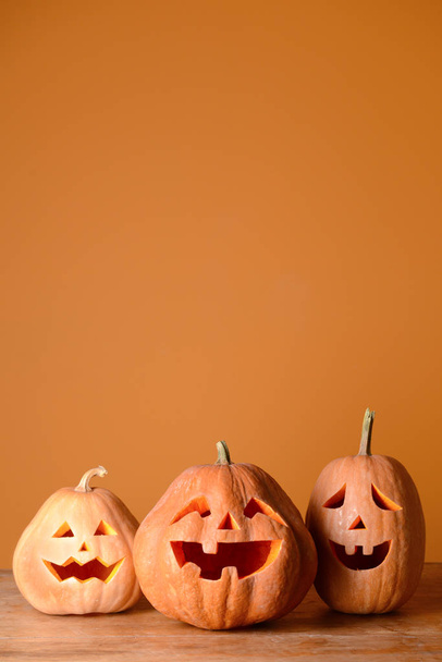 Halloween pumpkins on wooden table against color background - Photo, Image