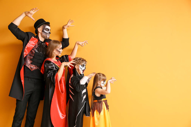 Family in Halloween costumes on color background - Photo, Image
