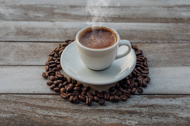 コーヒー豆をこぼした白い素朴な木製のテーブルの上にトルコやギリシャのホットコーヒー。これは、ギリシャやトルコの料理文化から伝統的なおいしいリフレッシュメントギリシャやトルコのコーヒーです。 - 写真・画像