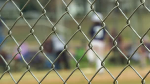 Slow motion of baseball game seen from behind a fence - Footage, Video
