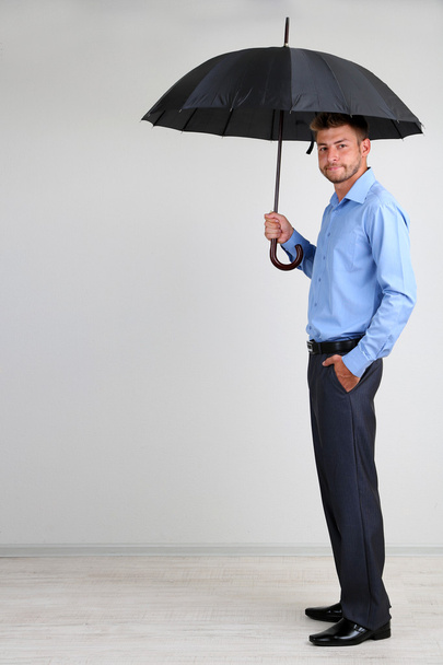 Businessman with umbrella. on gray background - Foto, Imagen