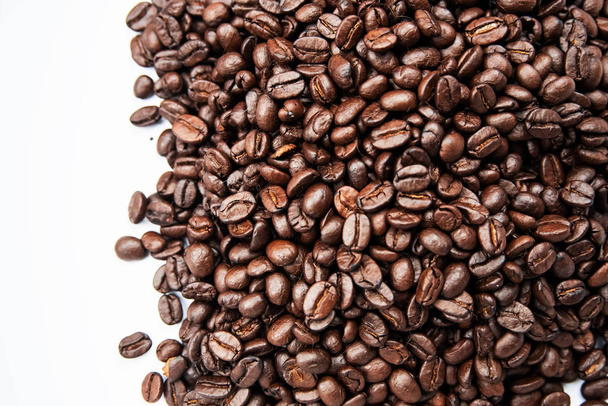 Primer grupo de granos de café sobre fondo blanco, luz borrosa alrededor
 - Foto, imagen