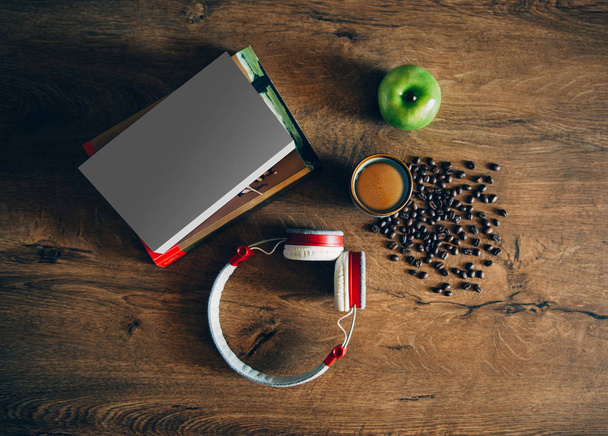 Livros, xícara de café, grãos de café, fone de ouvido e maçã verde na mesa de madeira. Estudo, trabalho ou ambiente relaxante
 - Foto, Imagem