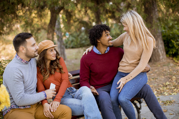 Группа молодых многонациональных друзей развлекается в осеннем парке
 - Фото, изображение