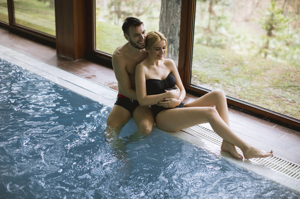 Aimant jeune couple relaxant dans le centre spa près de la piscine
 - Photo, image