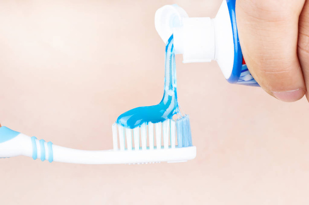 pasta de dentes é aplicada à escova de dentes, escovação de dentes na mão
 - Foto, Imagem