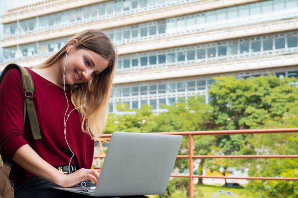 Young student using laptop outdoors.  - Fotó, kép