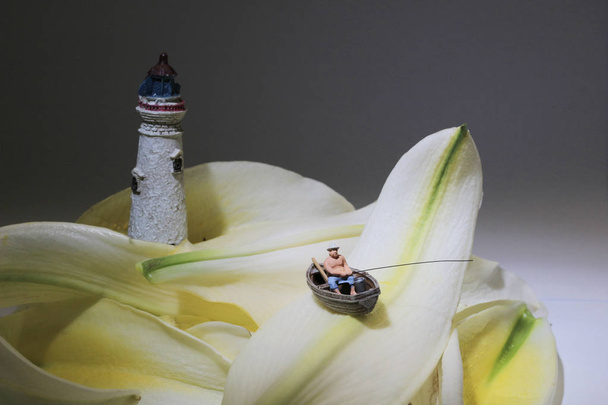 the mini figure is fishing on the flower - Photo, Image