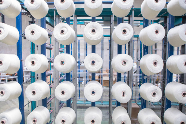 Group of bobbin thread cones on a warping machine in a textile mill. Yarn ball making in a textile factory. Textile industry - yarn spools on spinning machine in a textile factory - Photo, Image