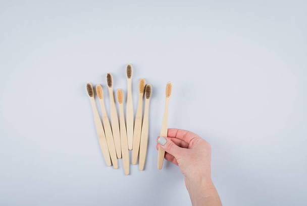 Flat lay composition with bamboo toothbrushes on grey background. Eco natural bamboo toothbrushes. Zero waste, plastic free items concept. Top view, copy space - Фото, изображение
