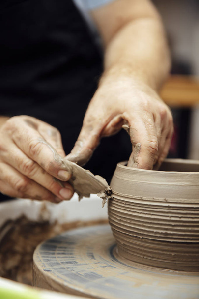 Vista de detalle de cerca en un artista de correo hace cerámica de arcilla en una rueda giratoria
 - Foto, imagen