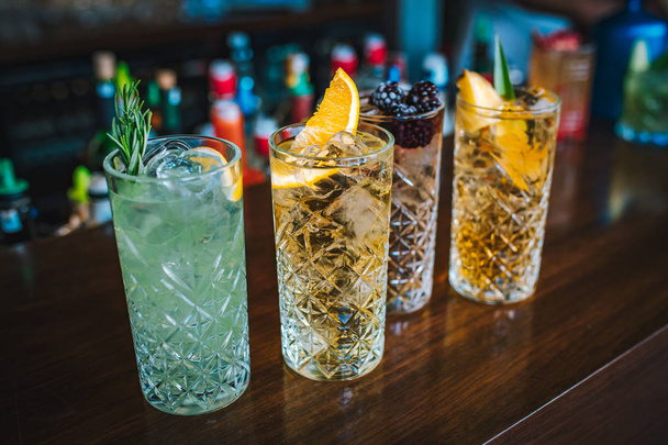Erfrischende und frische farbenfrohe alkoholische Mojito-Cocktails mit Limette, Erdbeere und Beeren auf dem Bartisch. Dies ist Sommer Erfrischungsgetränk exotischen bunten Cocktail. - Foto, Bild