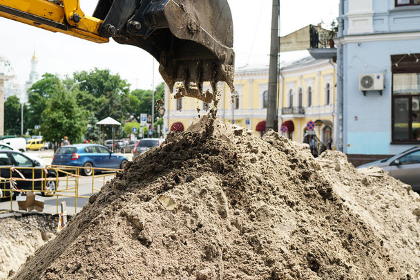 maquinaria de construcción en el sitio de construcción de la carretera en la cantera está ganando terreno y vertiendo arena
 - Foto, Imagen