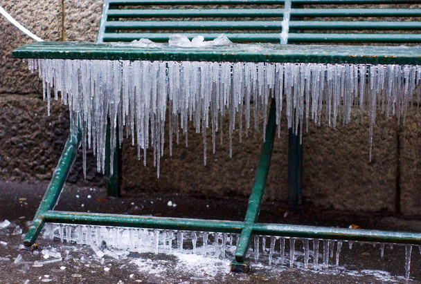 banco de metal ao ar livre, todos cobertos com gelo e icicles
 - Foto, Imagem