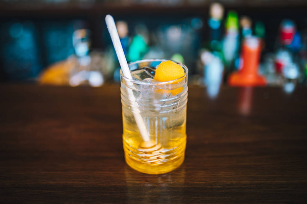 Φρέσκο πολύχρωμο εξωτικό αλκοολικό κοκτέιλ με λάιμ στο μπαρ. Πολύχρωμο χρυσό αναψυκτικό με λεμόνια στο γραφείο του μπαρ. Κοκτέιλ - Φωτογραφία, εικόνα