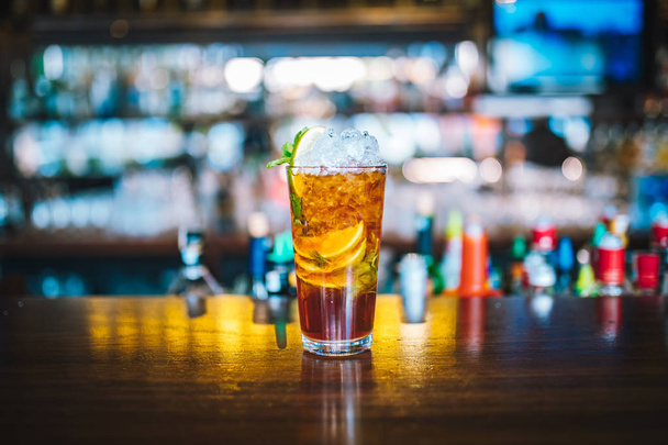 Cocktail alcoolisé exotique frais et coloré avec du citron vert au bar. Or coloré Boisson gazeuse avec des citrons sur le bureau du bar. Cocktail Jagermeister Mojito
 - Photo, image