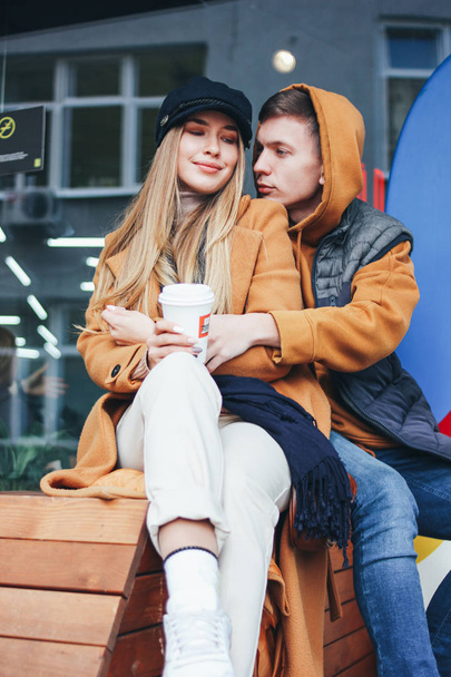 Happy young couple in love teenagers friends dressed in casual style walking together on city street in cold season - Foto, Bild