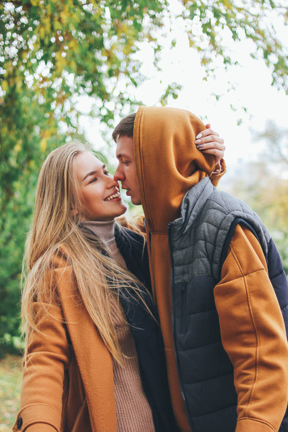 Boldog fiatal pár a szerelemben tinédzserek barátok öltözött alkalmi stílus csók a város utcáin a hideg szezonban - Fotó, kép