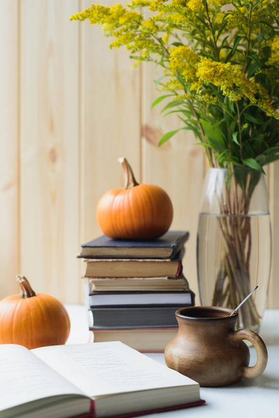 autumn still life with books, pumpkins, cup, solidago bouquet - Foto, Imagem