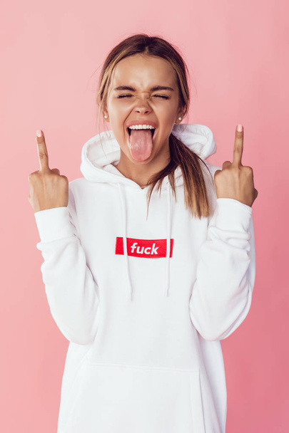 Young emotional woman shows middle finger. - Foto, imagen