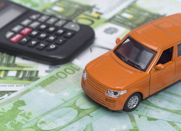 πορτοκαλί αυτοκίνητο και χρήματα, ευρώ και δολάρια. ασφαλιστική έννοια - Φωτογραφία, εικόνα