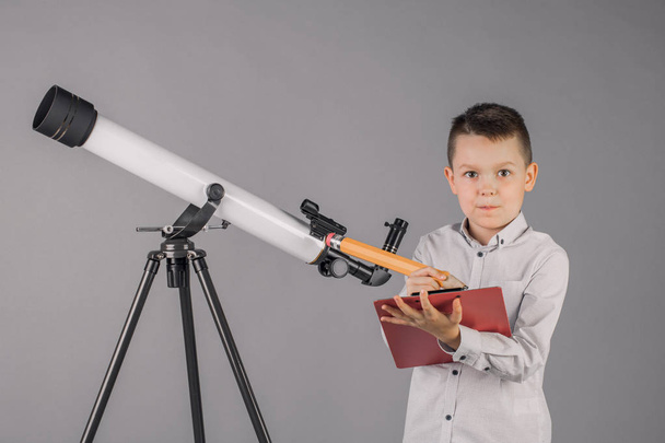 молодий астроном дивиться через телескоп і пише на вкладці
 - Фото, зображення
