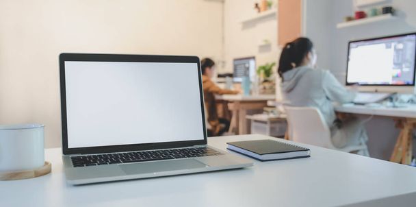 Відкрити порожній екран ноутбук на білому дерев'яному столі з офісними приладдям з бізнес-леді на задньому плані
  - Фото, зображення