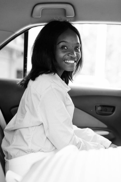 Joven hermosa mujer de negocios africana Zulu cabalgando dentro del coche
 - Foto, imagen