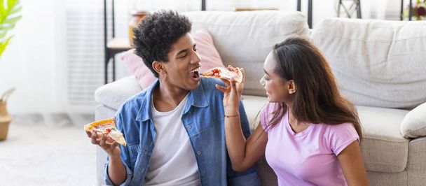 ピザを食べて、自宅で笑う幸せなカップル - 写真・画像