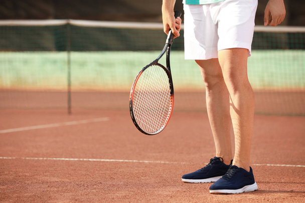 Jeune homme jouant au tennis sur le terrain
 - Photo, image
