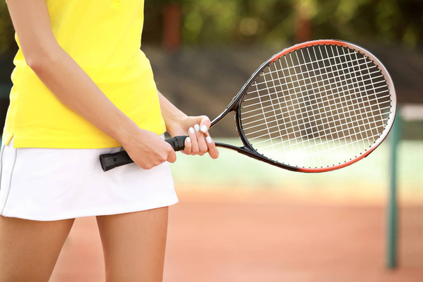 Young woman playing tennis on court - Photo, Image