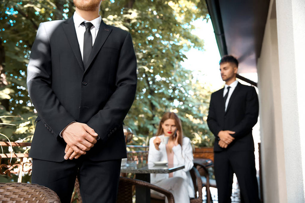 Young businesswoman with bodyguards in cafe - Photo, Image