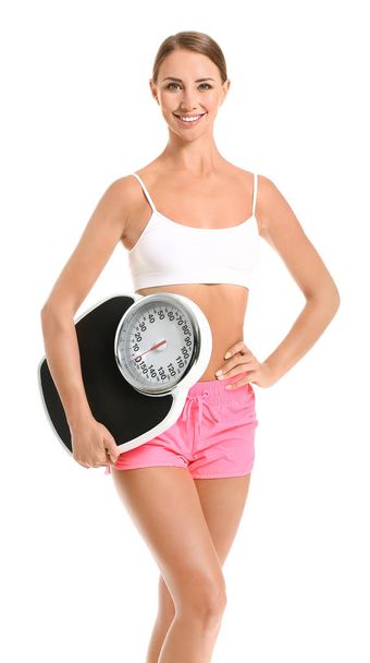 Beautiful young woman with scales on white background. Weight loss concept - Φωτογραφία, εικόνα
