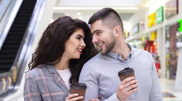 Jeune couple boire du café pour aller après de longs achats
 - Photo, image