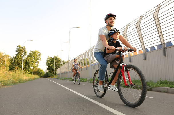 Счастливая семья ездит на велосипедах на открытом воздухе
 - Фото, изображение