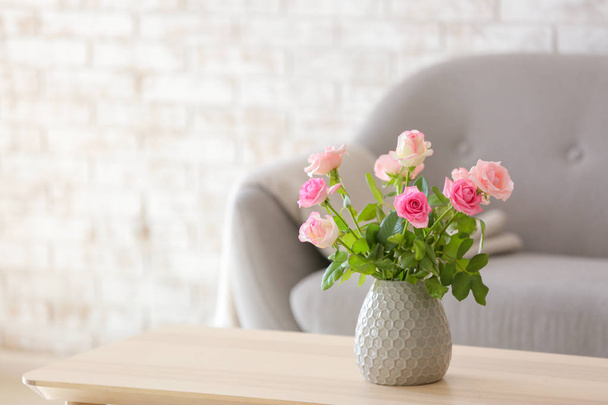 Beautiful rose flowers in vase on table in room - Φωτογραφία, εικόνα