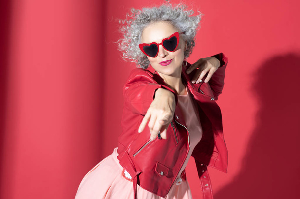 Curly woman wearing red leather jacket moving and posing - Foto, Imagem