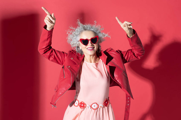 Woman in pink dress and red jacket moving and laughing - Fotografie, Obrázek