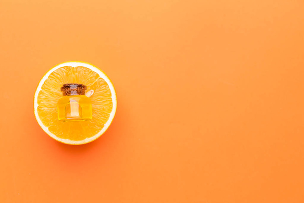 Bottiglia di olio essenziale di arancia su sfondo colore
 - Foto, immagini