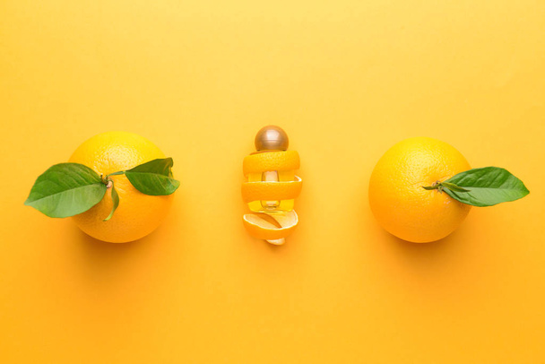 Composición con aceite esencial de naranja sobre fondo de color
 - Foto, imagen