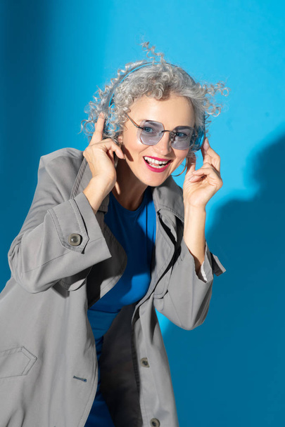 Cheerful woman wearing earphones listening to music - Fotoğraf, Görsel
