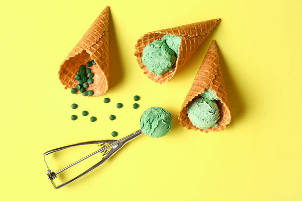Waffle cones with tasty spirulina ice-cream on color background - Foto, immagini