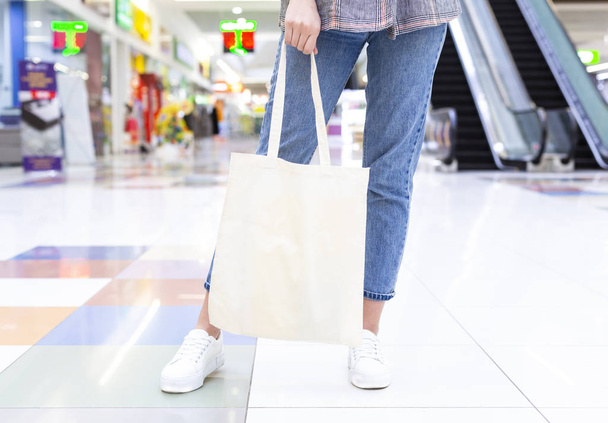 ショッピングセンターでブランクコットンエコトートバッグを持つ女の子 - 写真・画像