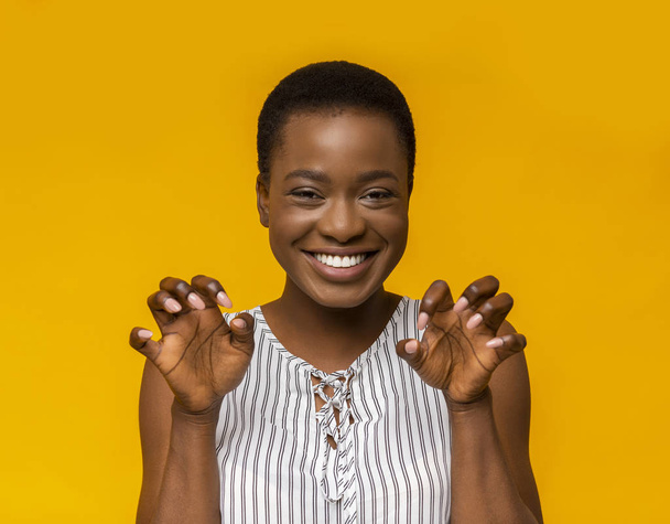 Giocoso africano americano ragazza ringhiando su sfondo giallo
 - Foto, immagini